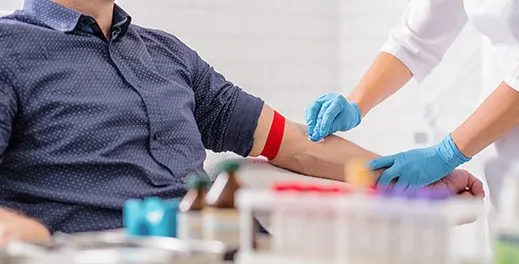 Nurse collecting a blood sample from a patient's arm