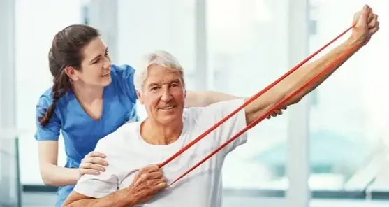 Therapist helping an older woman stretch with a resistance band