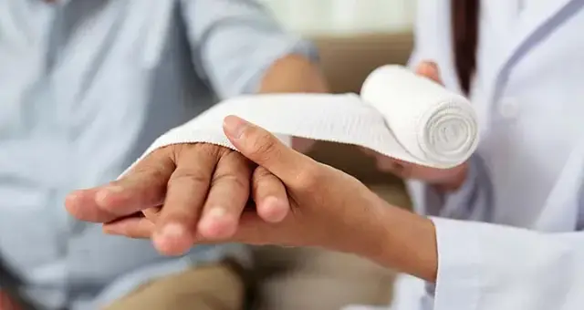 Clinician wrapping a bandage around a patient's hand