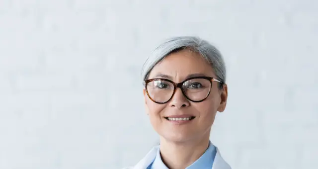 Smiling doctor wearing glasses and a white coat