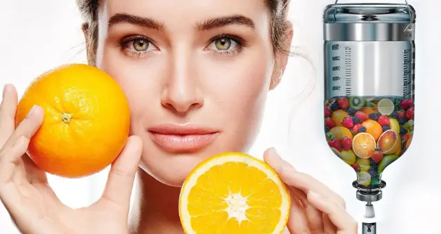 Woman holding orange halves next to an IV drip bottle