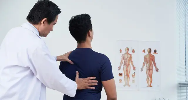 Physiotherapist assessing a patient's back
