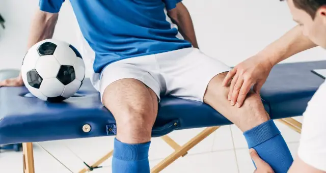 Physiotherapist treating a footballer's knee